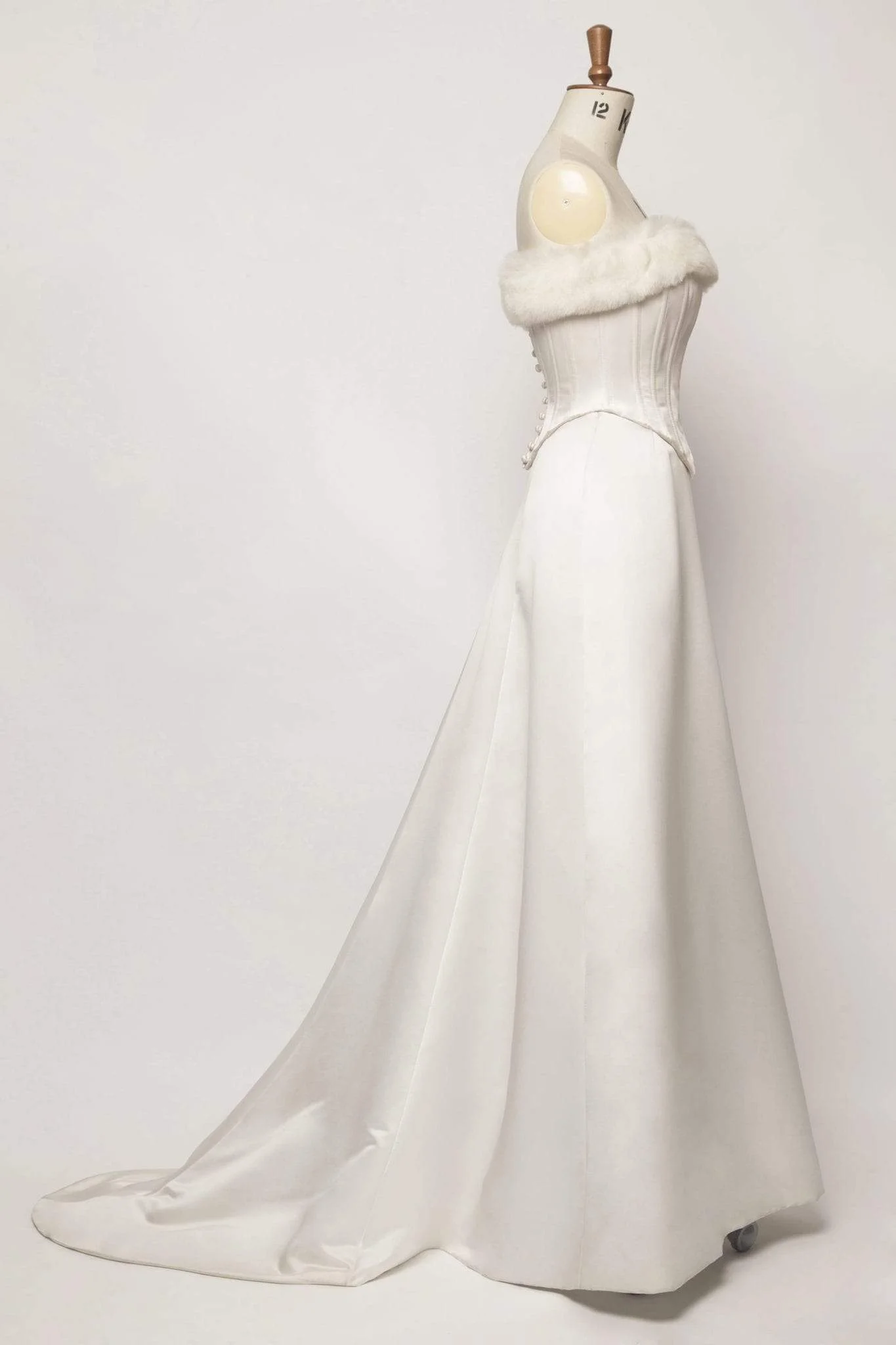 Bells of Ireland fur trim wedding dress side view on mannequin showing cathedral train and structure
