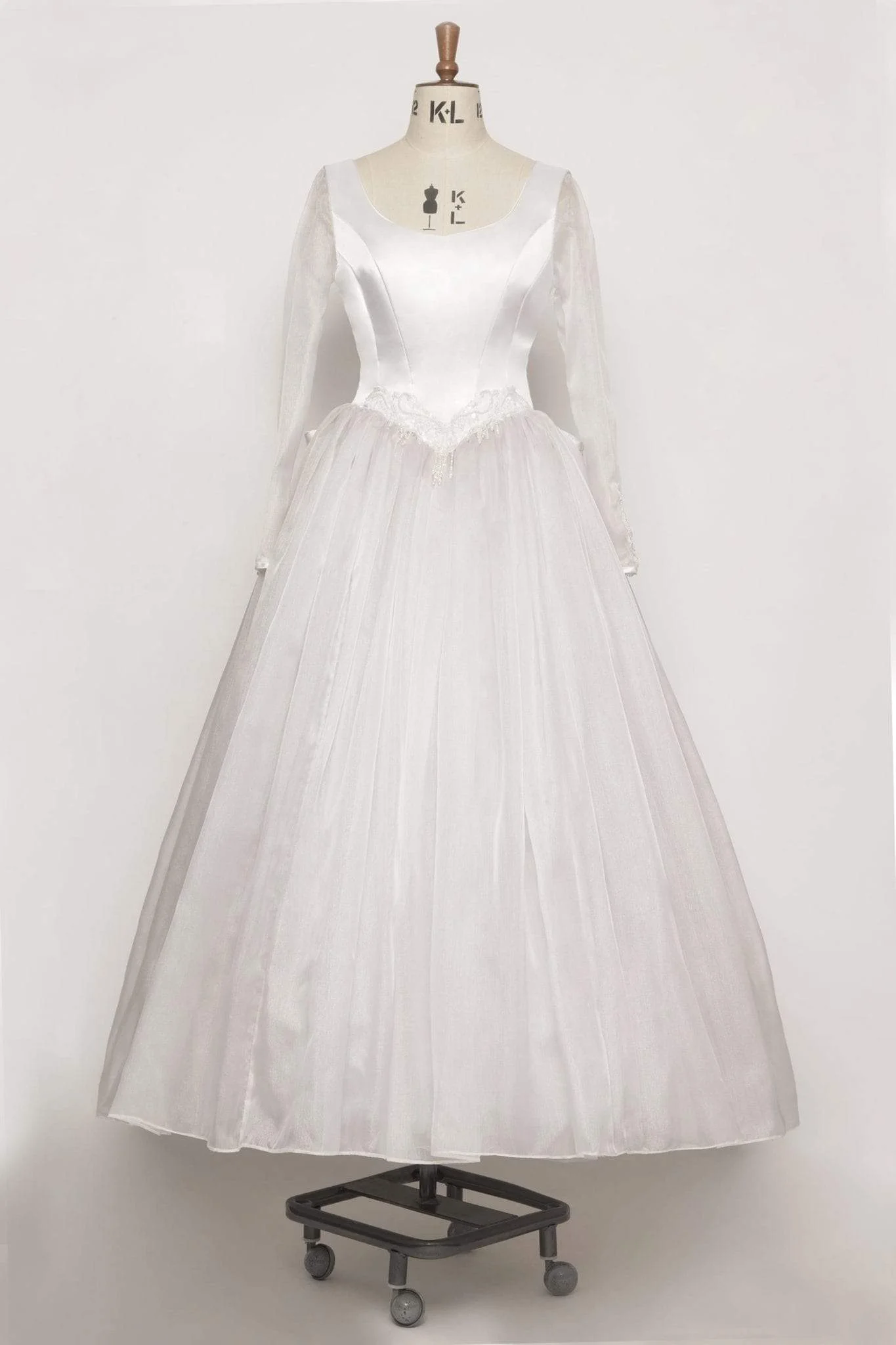 80s - wedding dress with satin bodice, organza sleeves, beaded motifs, large satin bow with tails, and full organza skirt. Size 10