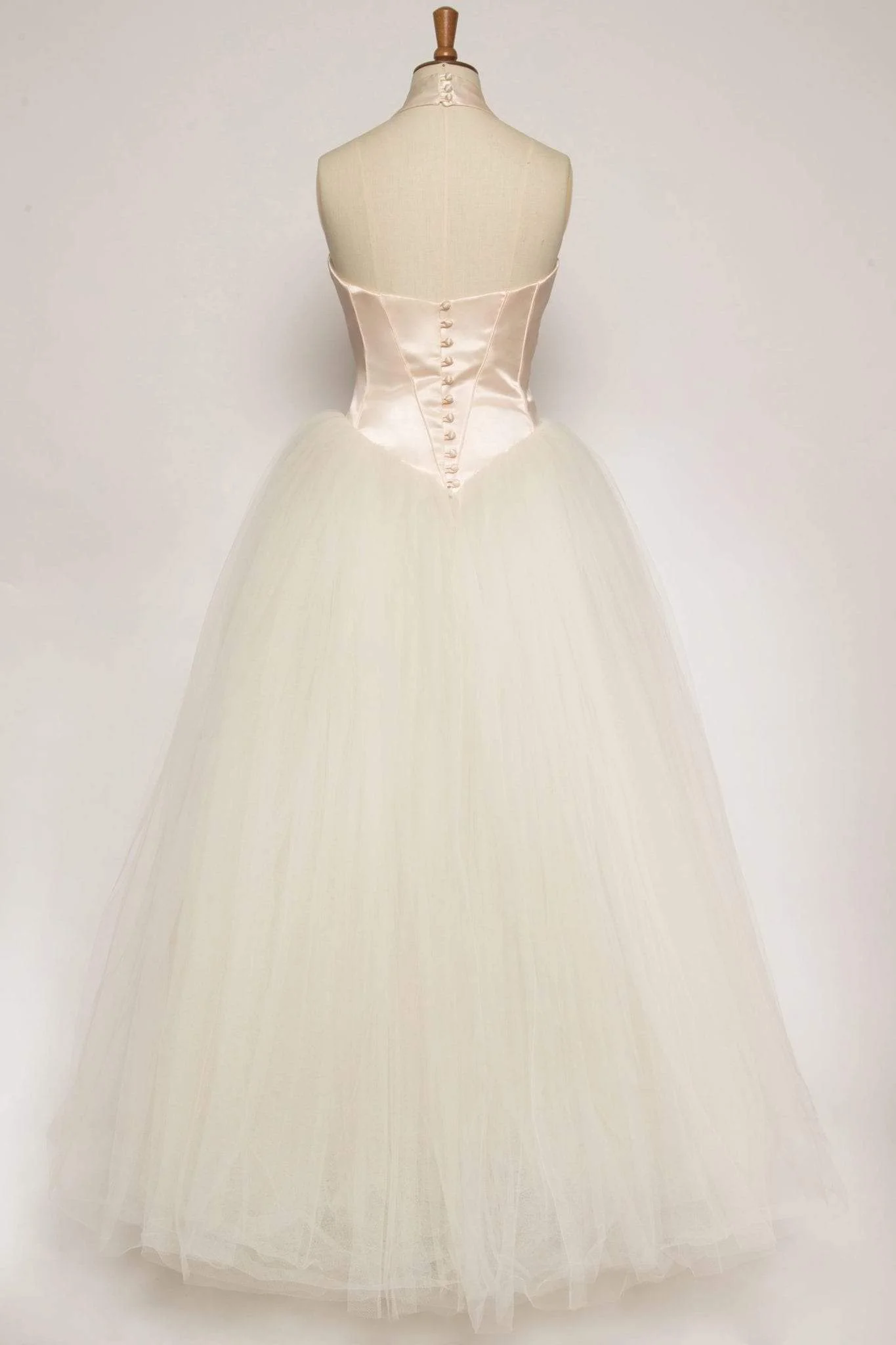 Peach duchess satin halter gown with sweetheart bodice, full tulle skirt, piped edges, and covered buttons, perfect for a fairytale princess look.