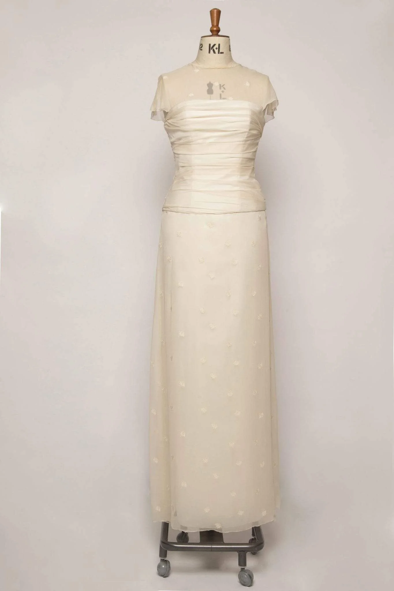 Front view of long flowing ruched ivory silk chiffon A-line dress, size 10, with sheer overlay and delicate embroidery