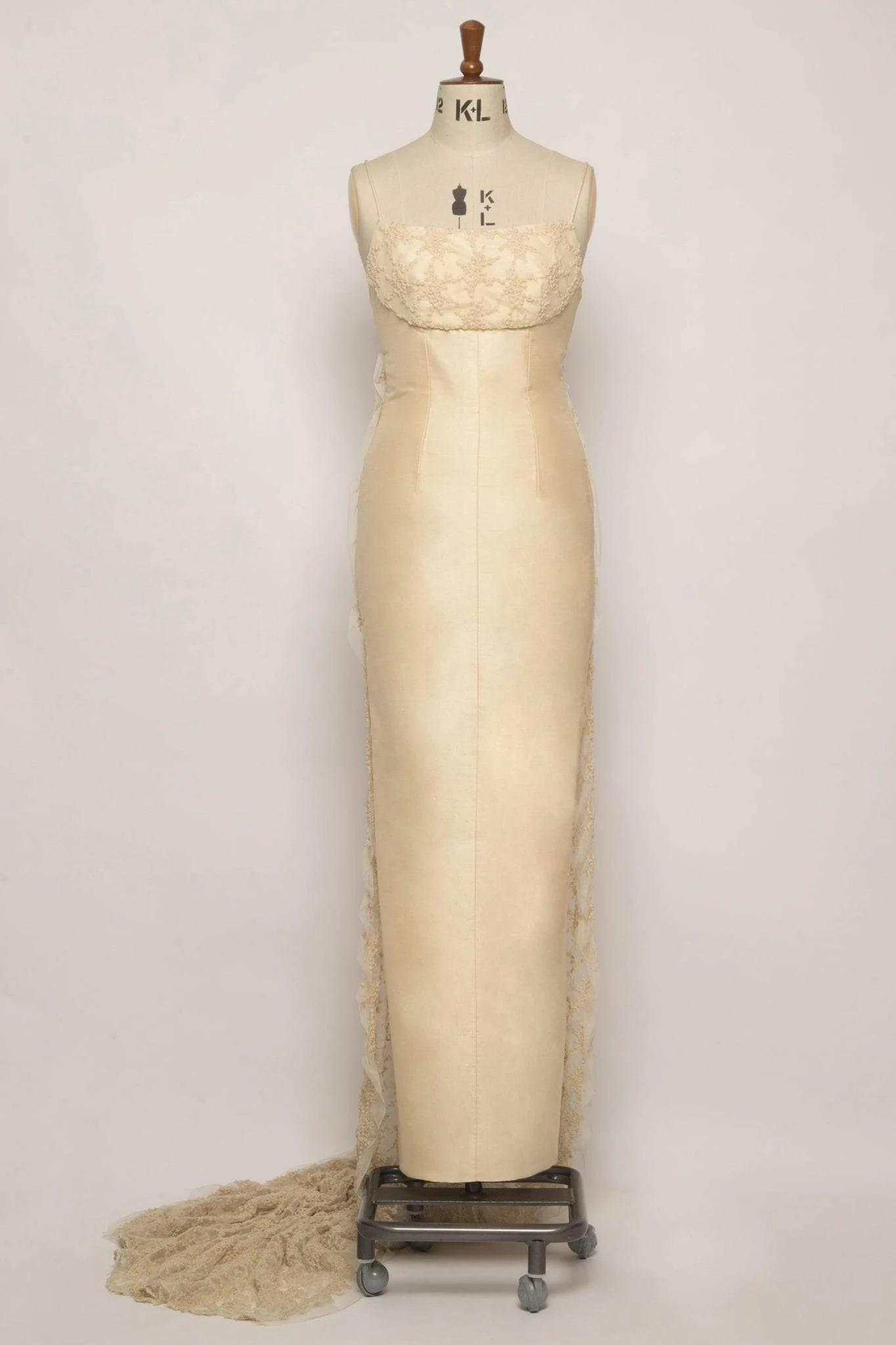 Champagne silk dupion empire column bridal gown with shoestring straps, embroidered tulle bust detail, and cascading Watteau train