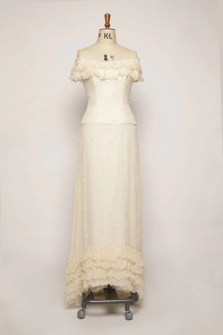 A-line long flowing chiffon dress with ruffles, small train, and off-the-shoulder fitted bodice with cap sleeves in silk embroidered chiffon.