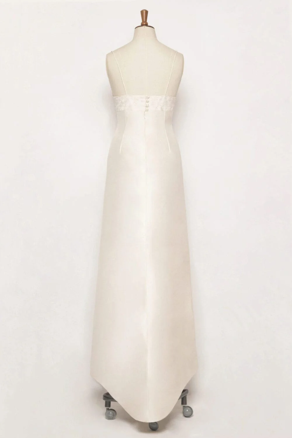 A-line silk dupion dress with a round neckline, spaghetti straps, embroidered bodice, covered working buttons at the back, and a mini puddle train.