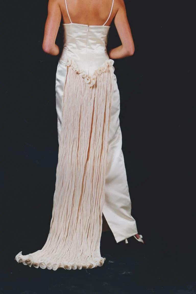 Sweetheart neckline wedding dress in champagne duchess satin with shoestring straps, crushed silk bust detail, and detachable train