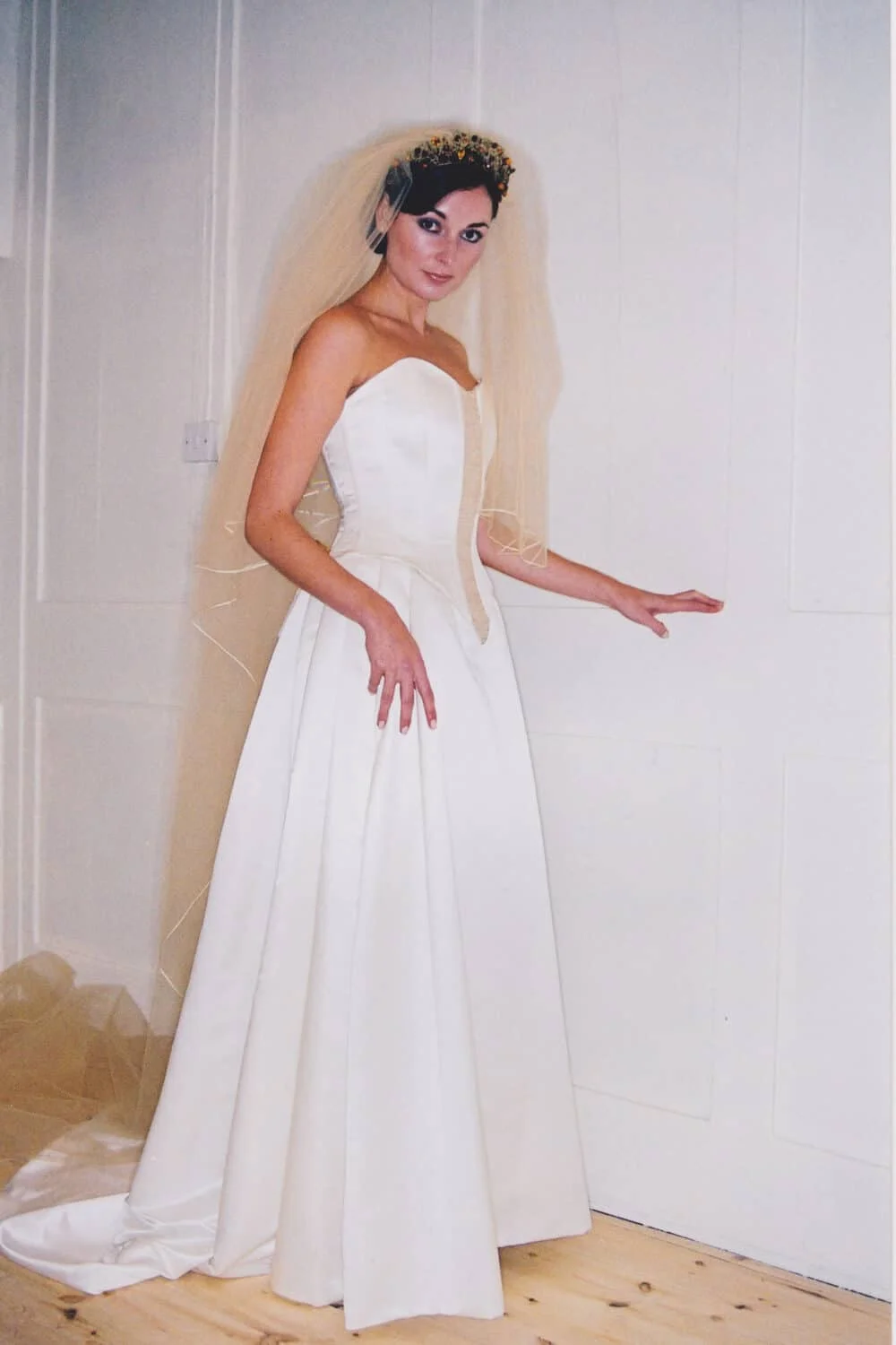 Strapless ball gown with heavily boned corset, laced back, gold embroidery, V-shaped drop waist, satin skirt, and chapel-length train